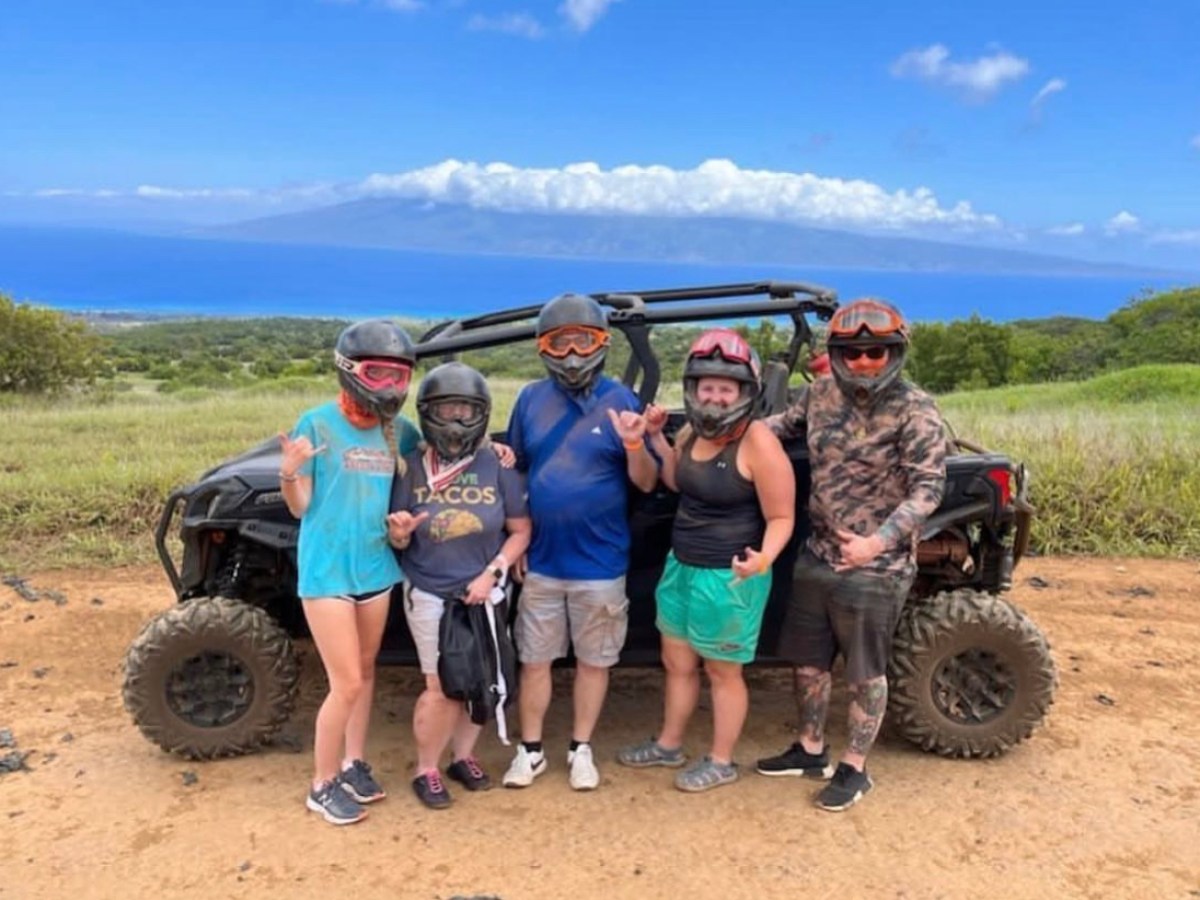 a group of people standing on top of a dirt field