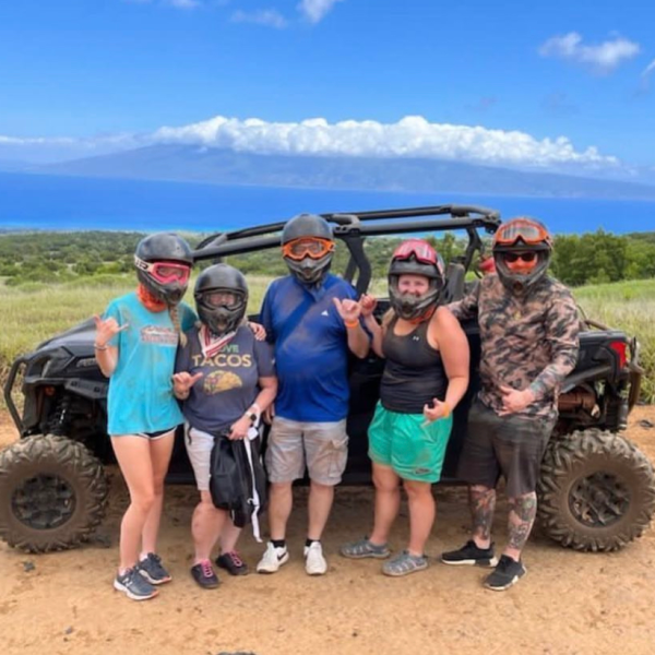 a group of people standing on top of a dirt field