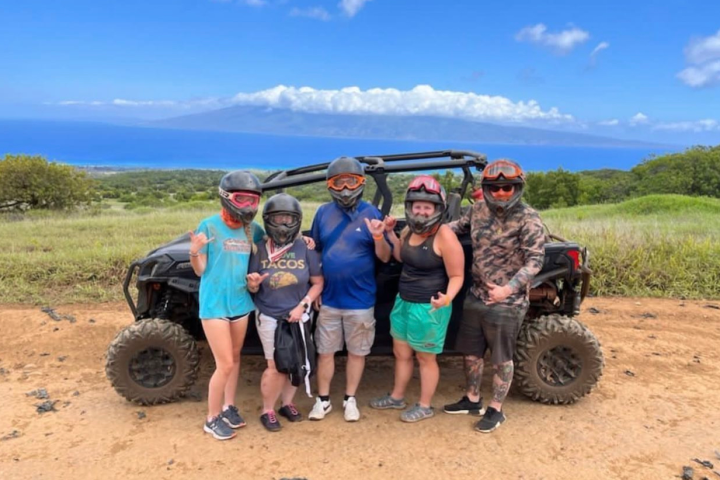 a group of people standing on top of a dirt field